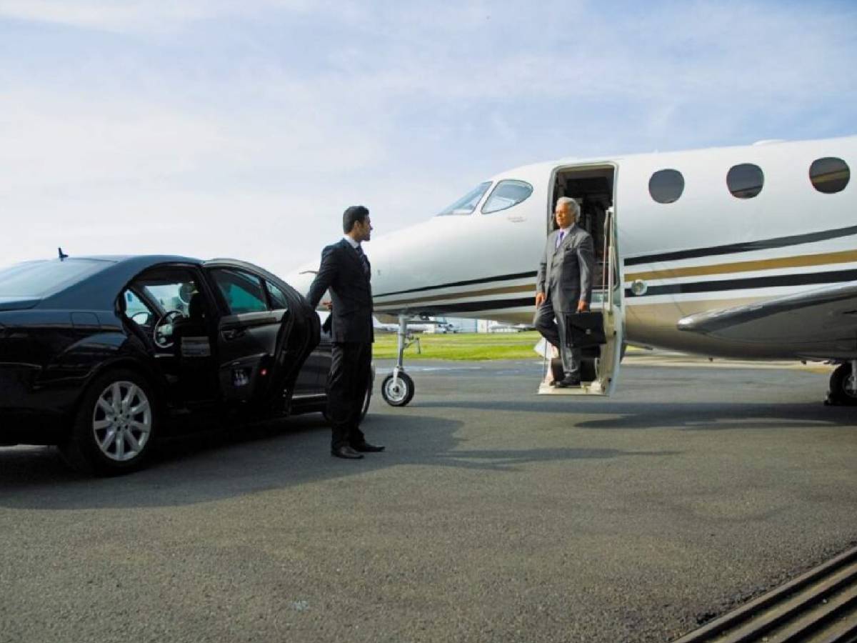 Luxury black car transporting private jet passengers at FBO in Dallas