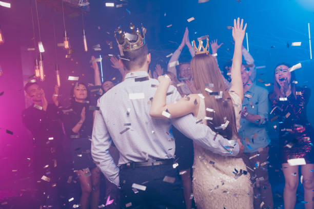 Group of teenagers dressed for prom celebrating in a luxury limousine