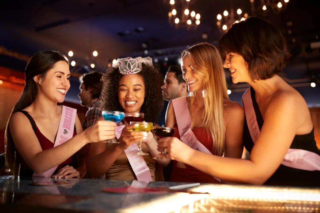 Group of female friends celebrating with the bride on a hen party in a bar