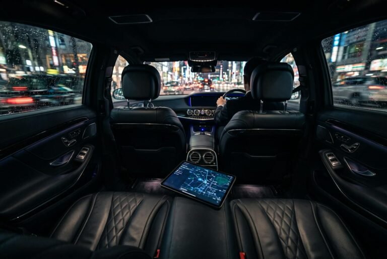 Back seat of a black luxury sedan at night for hourly chauffeur service